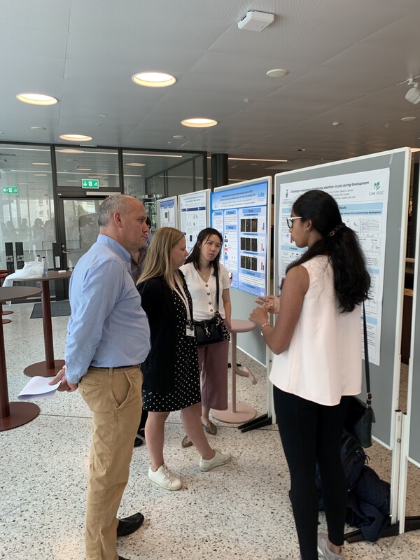 photo of students and instructors discussing a poster presentation